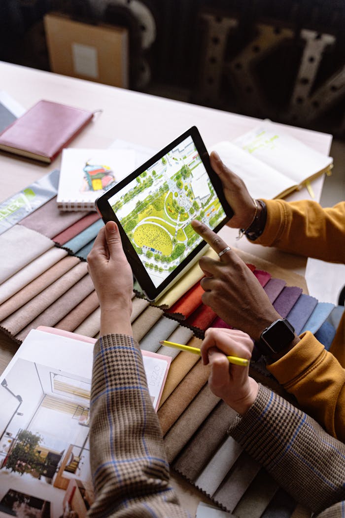 Two architects working on a project, using a tablet to review landscape designs.